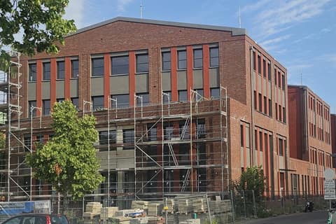 Brick façade of a multi-storey office building with scaffolding