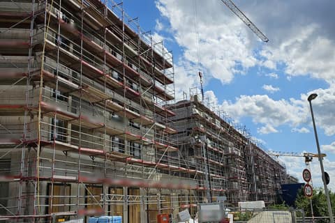 Scaffolded structural shell of a multi-storey building complex with crane