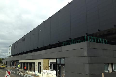 Dark façade cladding of a large hall under construction