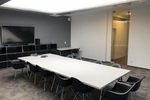 Completed meeting room with long table, screen and sideboard